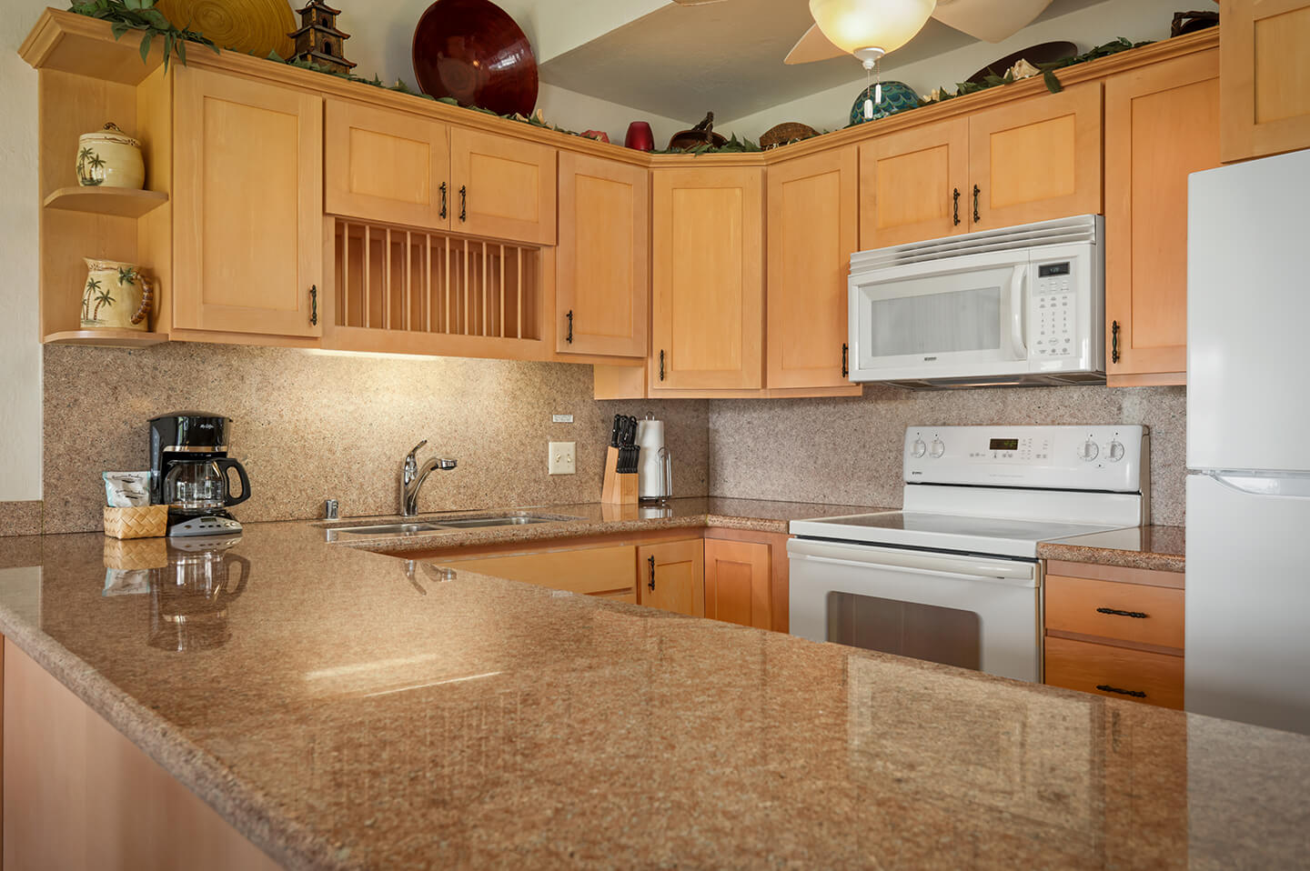 Kitchen counter top, stove, refrigerator, sink, microwave.