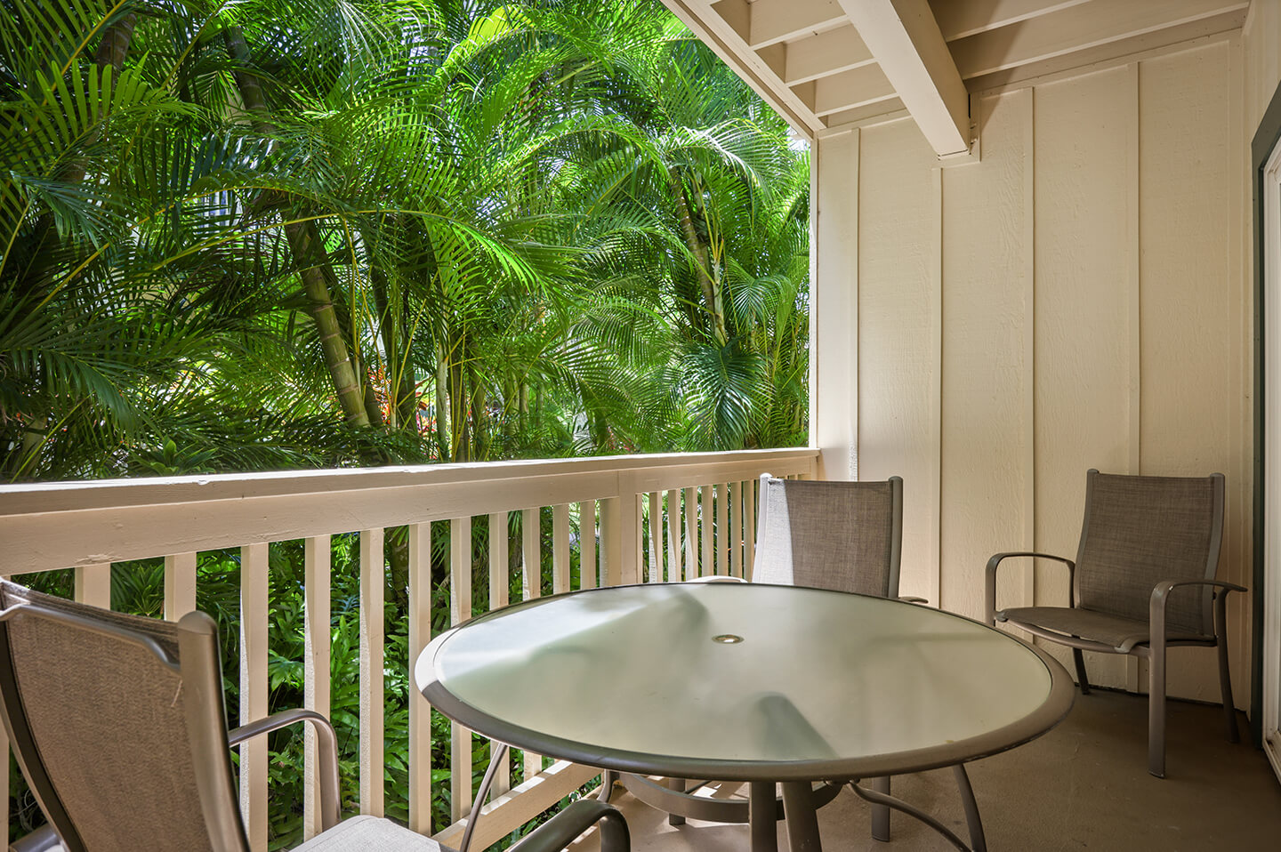 Balcony with table, chairs, garden view.