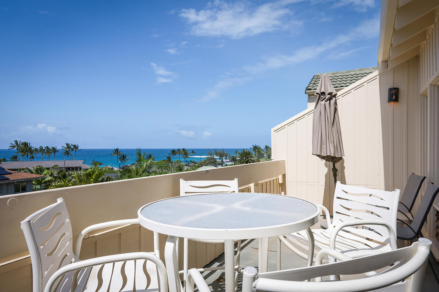 Balcony with table and chairs and ocean views.