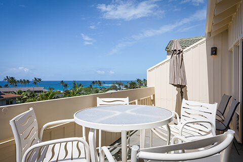 Balcony with tables, chairs, and ocean view