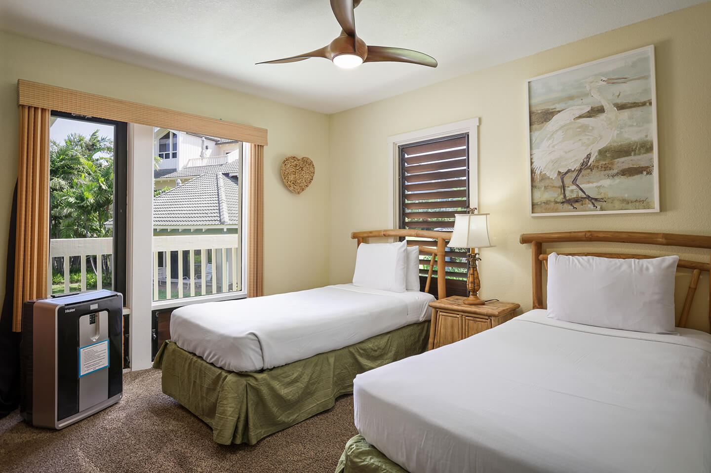 Room with 2 beds, night stand, lamps, patio.