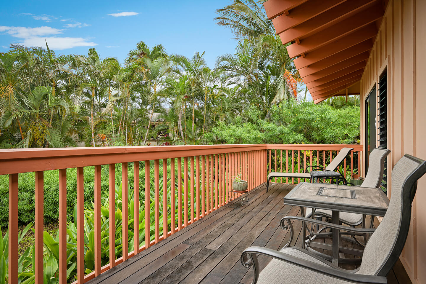 Balcony with table, chairs, garden view.