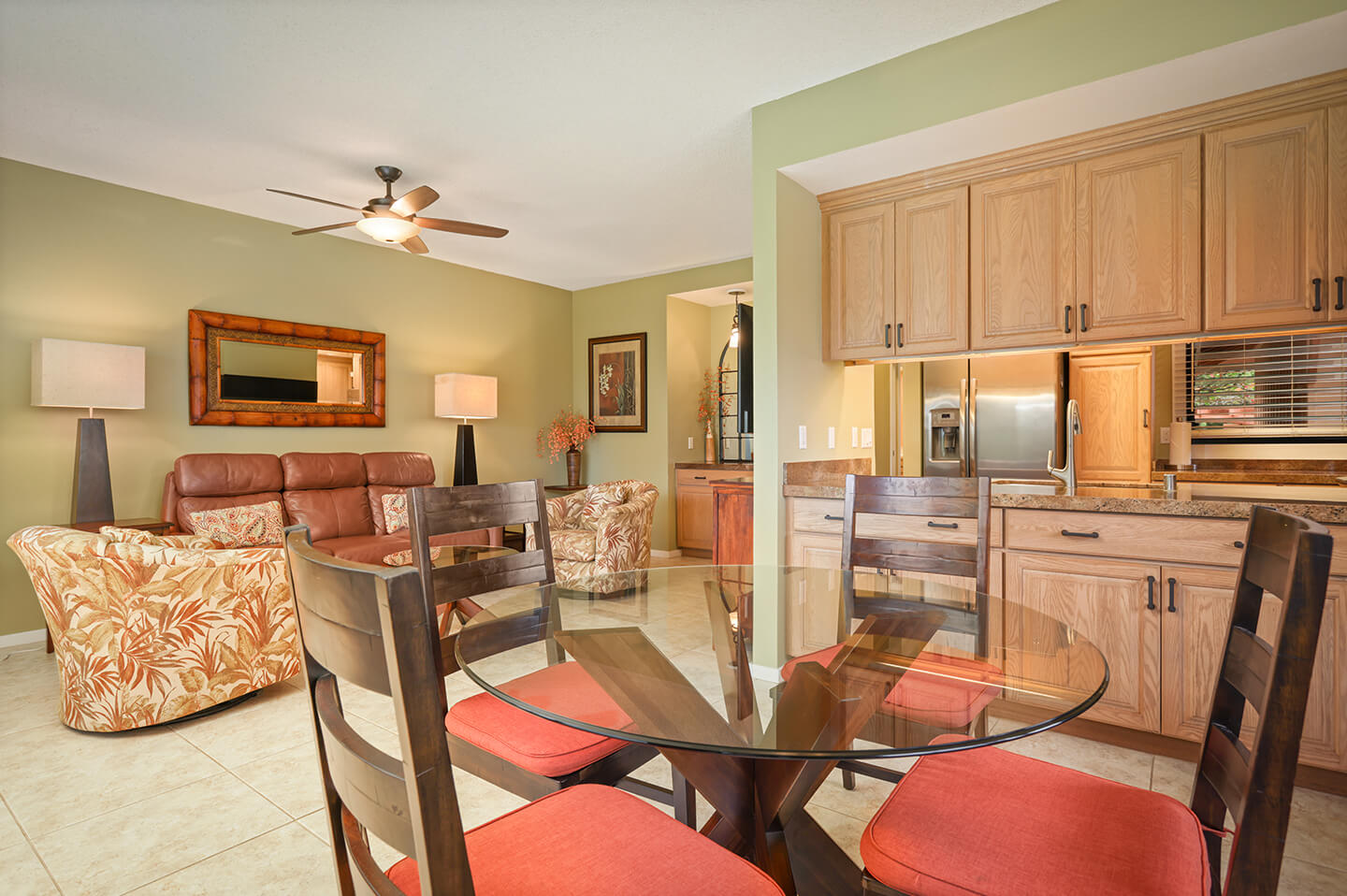 Dining area with table, chairs, kitchen and living area in background.