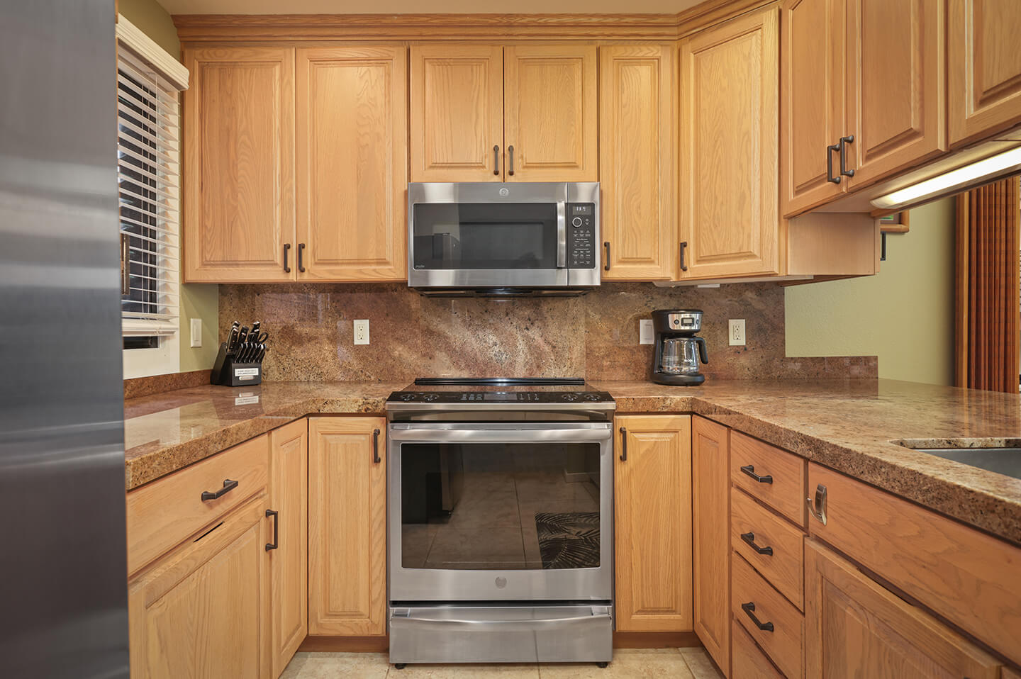 Kitchen with refrigerator, stove, microwave, sink.