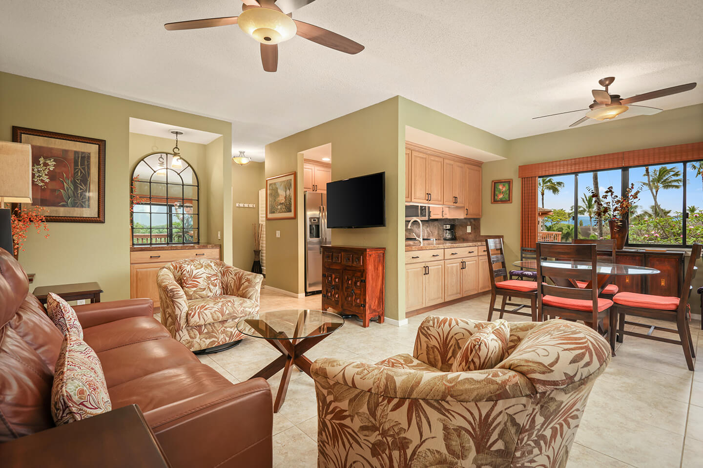 Living area with couch, seating, table, TV, balcony.