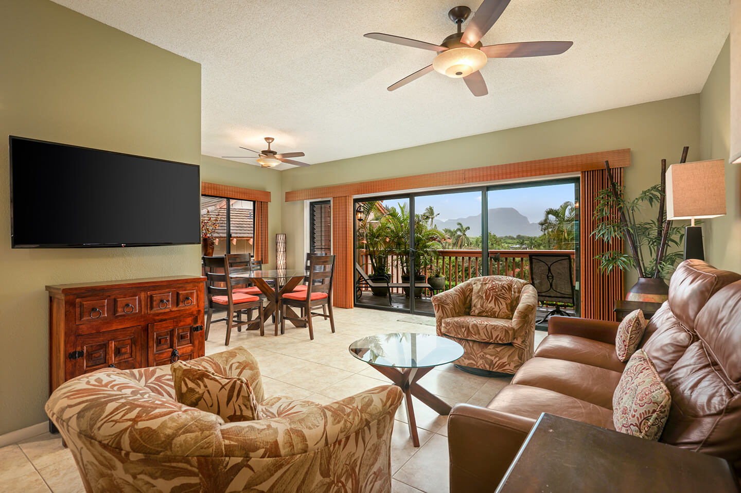 Living area with TV, couches, seats, table, balcony.