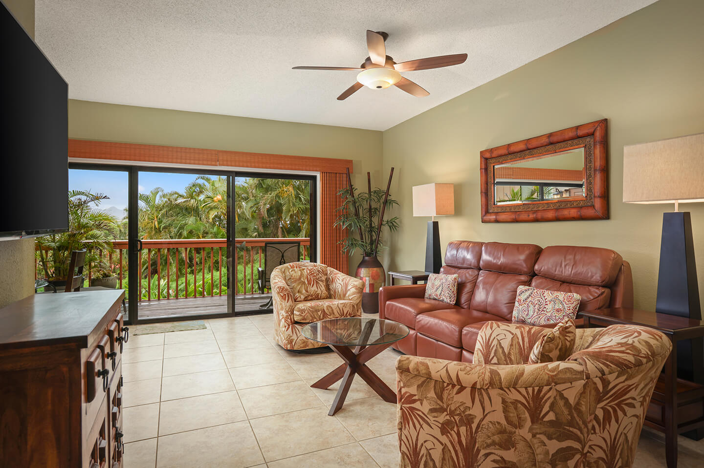 Living area with couch, seating, table, TV, balcony.