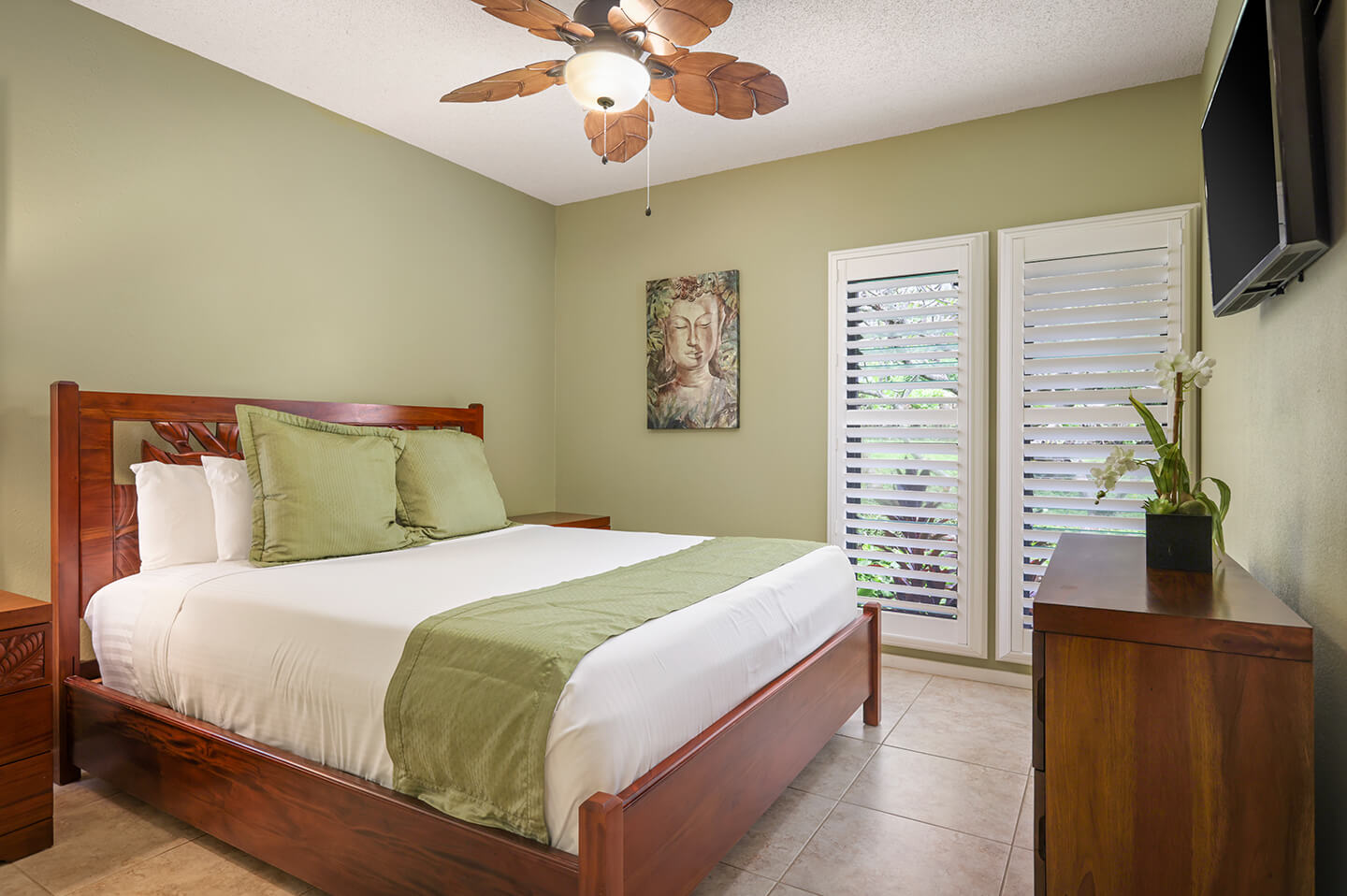 Bedroom with bed, TV, dresser, balcony.