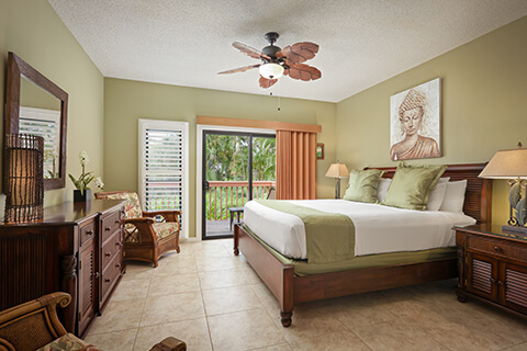 Room with bed, night stand, lamps, dresser, TV, balcony