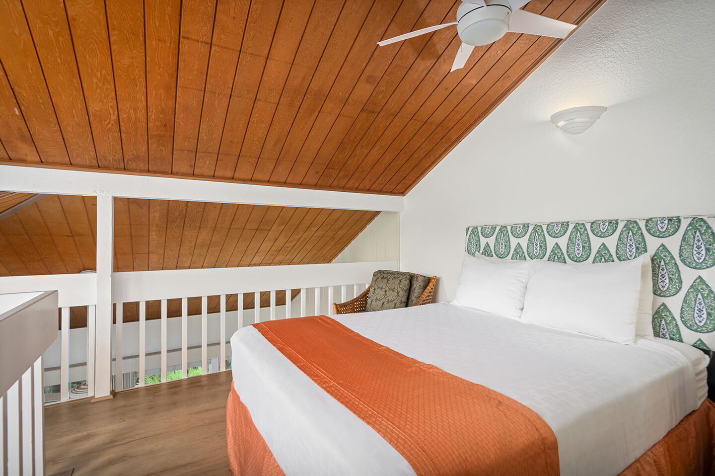 Loft room with a bed and ceiling fan.