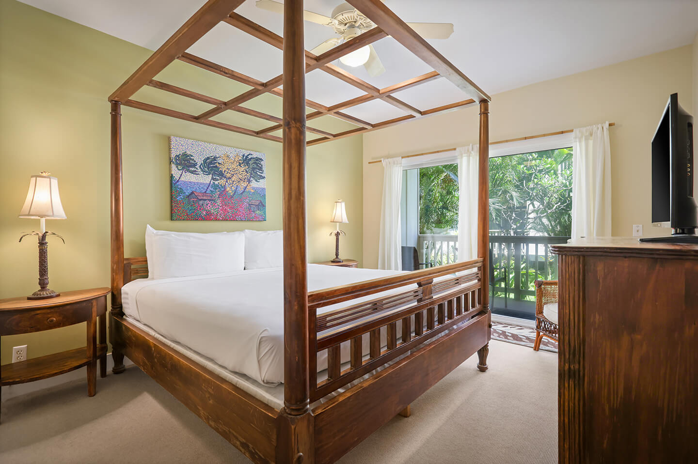 Room with 4 poster bed, night stands, lanps, dresser, TV, patio.