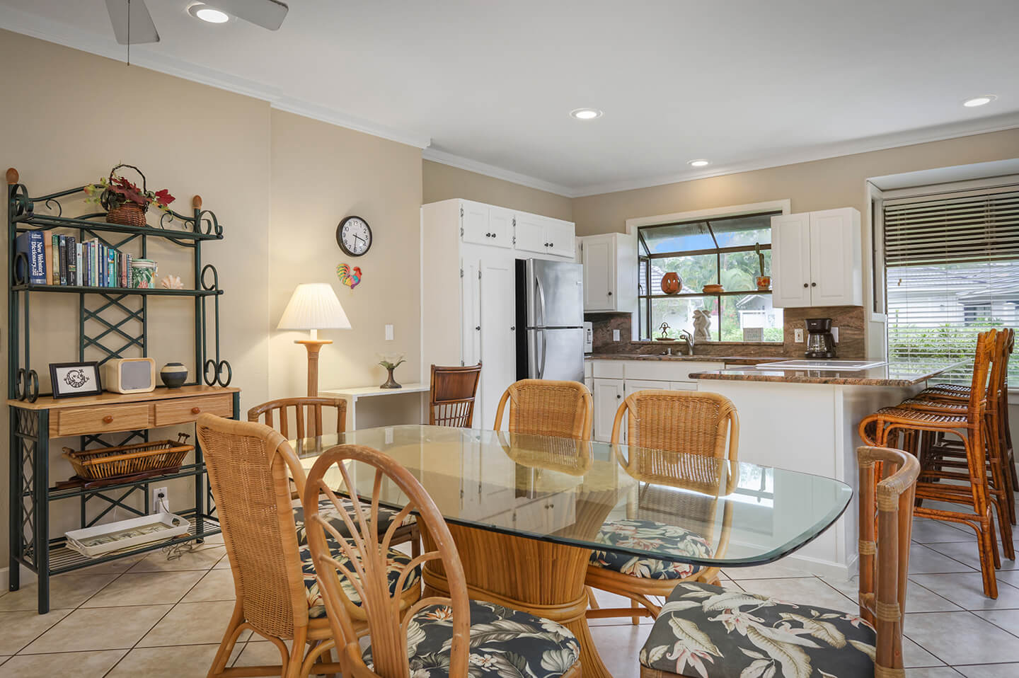 Dining area with table and chairs, kitchen in background.