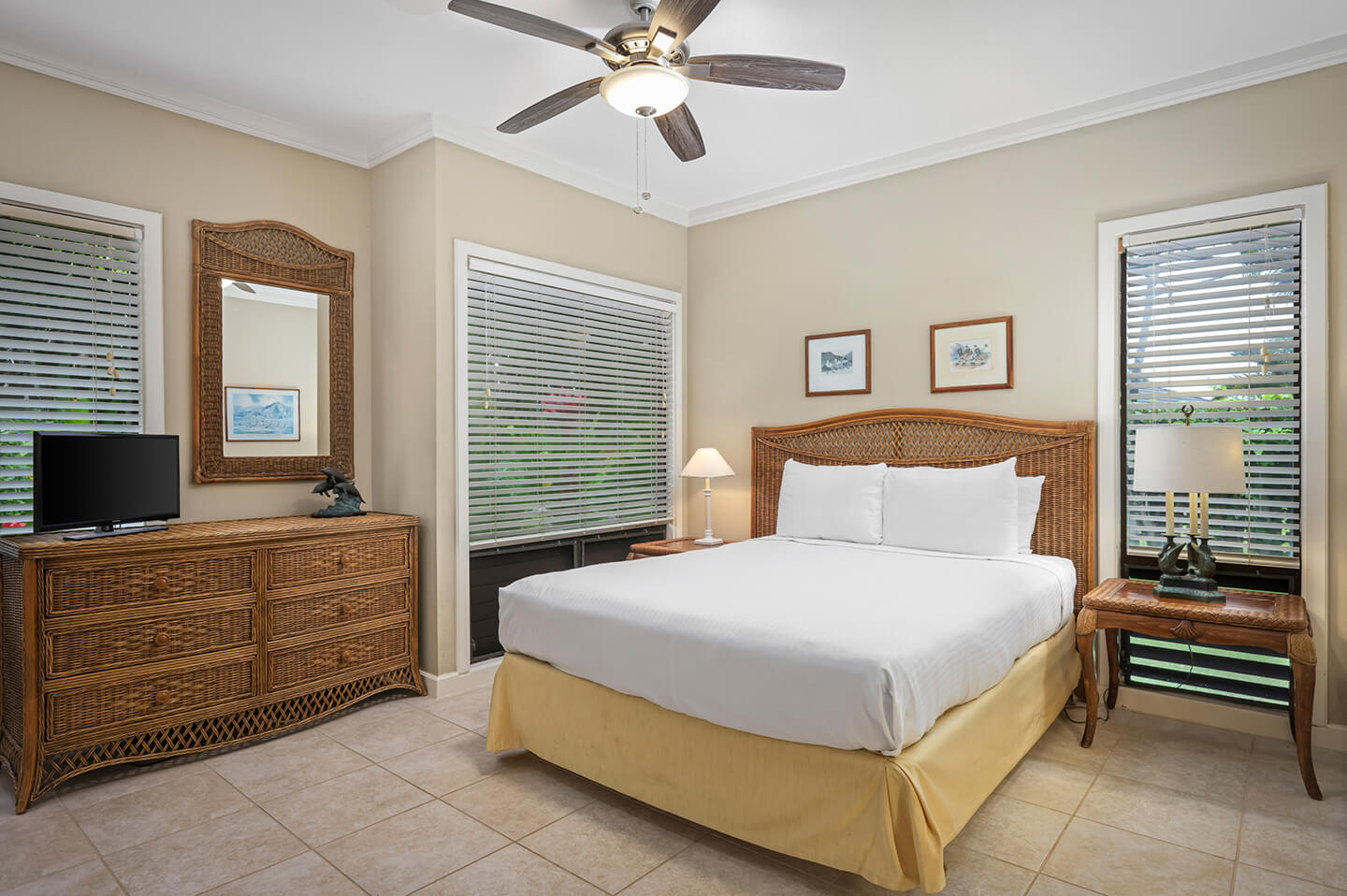 Room with bed, TV, dresser, lamp.