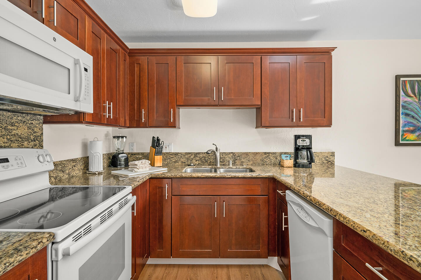 Kitchen stove, microwave, dishwasher, sink, counters, and cabinets.