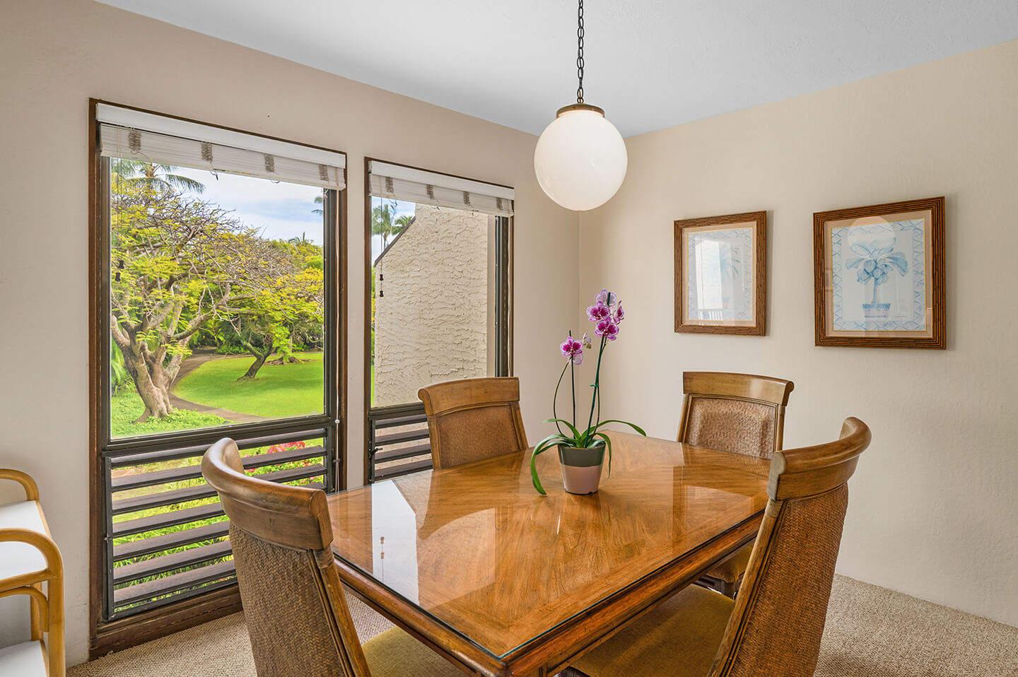 Dining table, chairs, and large picture window with garden views.