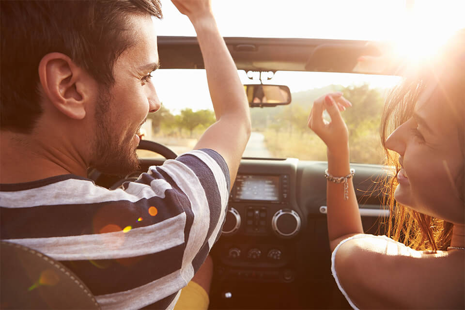 Couple riding in car with sunny background