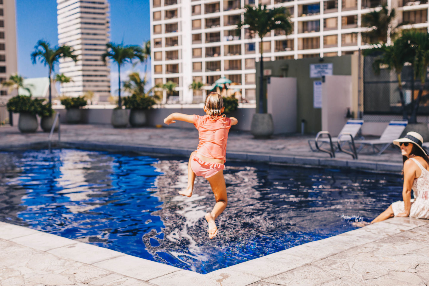 Girl jumping into swimming pool