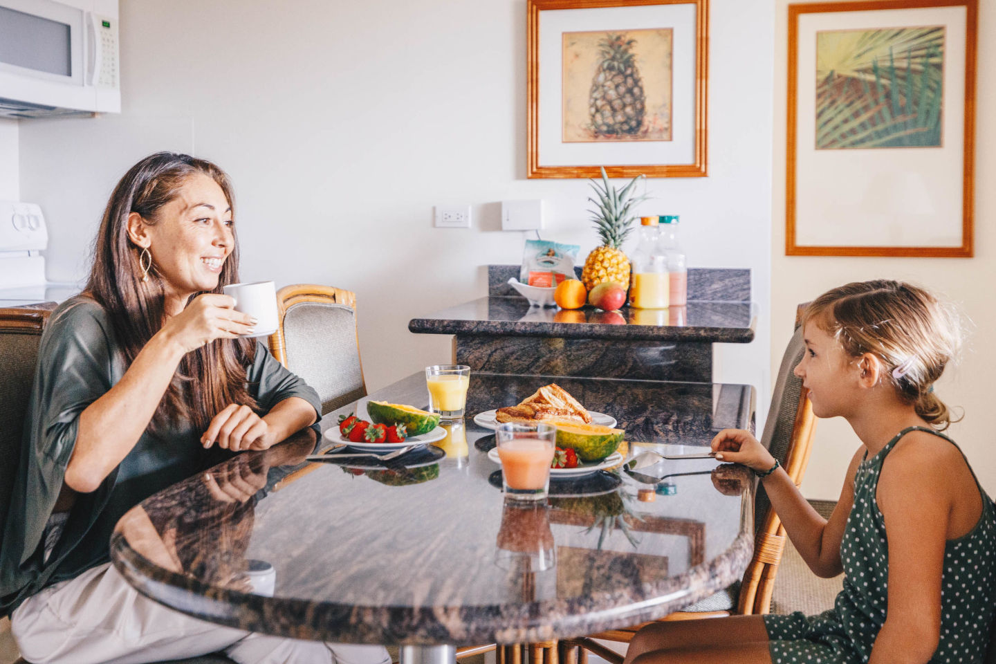 One-Bedroom Standard Suite Kitchen with lady and young girl enjoying breakfast 
