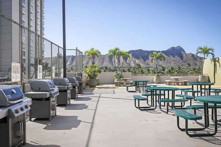 Recreation deck with grills, tables, view of Diamond Head.
