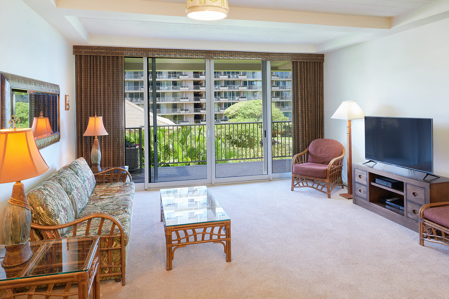 Living room with a couch, coffee table, TV, and balcony.