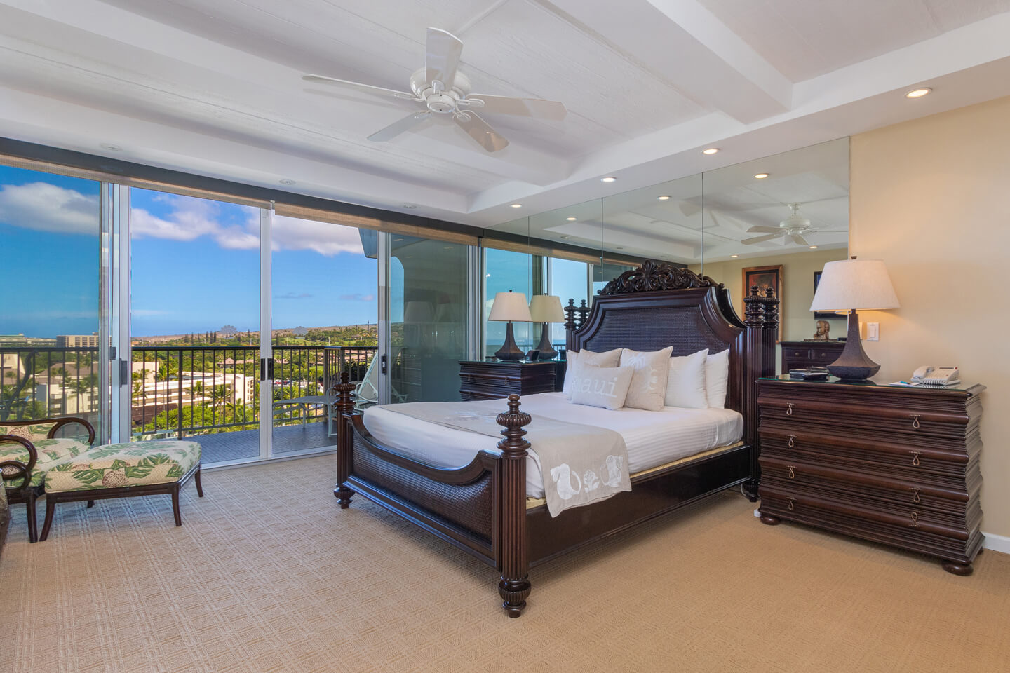 Room with a bed, dresser, lamps, and a balcony.