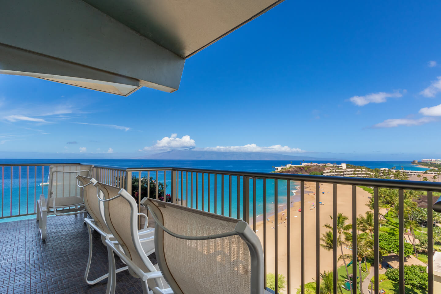 Balcony with chairs and beachfront views.