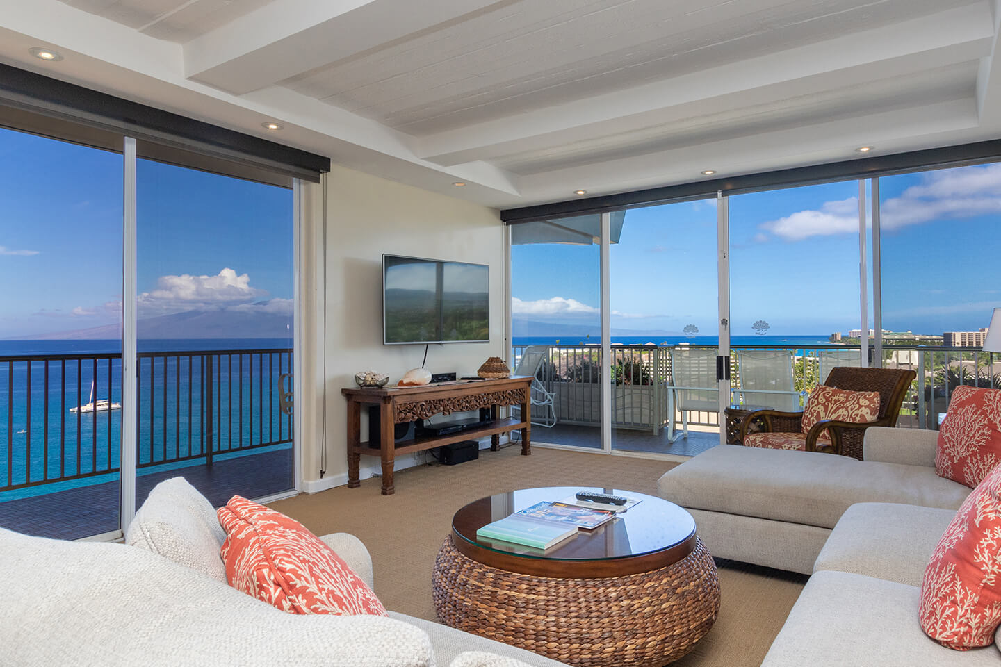 Living area with a couch, TV, and balcony with ocean views.