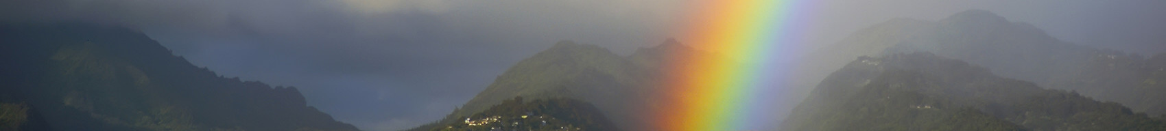 Rainbow over Honolulu against a rainy backdrop